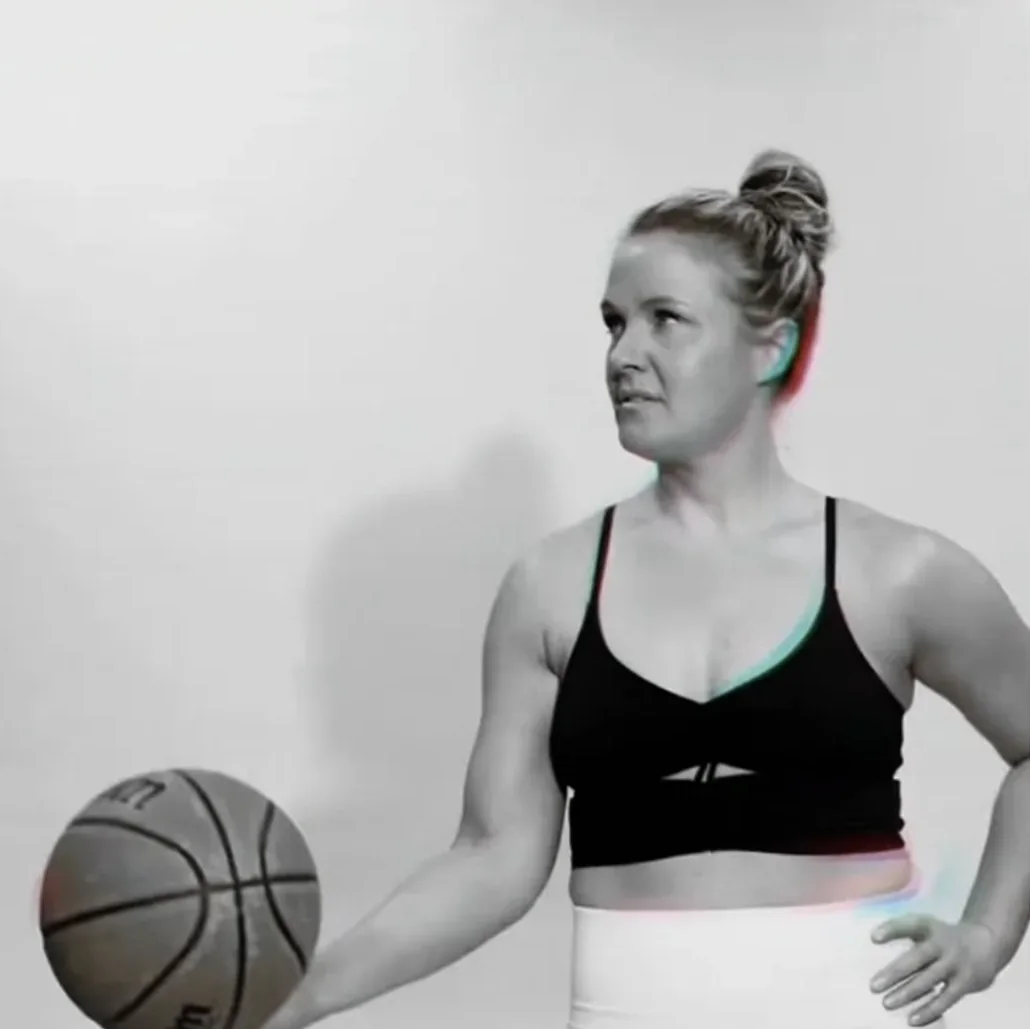 Black-and-white portrait of Jen Holley holding a basketball, hand on hip